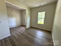 Unfurnished living room features wood-look flooring and lots of natural light at 168 Wildwood Loop, Statesville, NC 28625