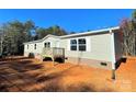 Side view of light colored siding and brick foundation with a small wood deck at 3357 34Th Avenue Ne Ct, Hickory, NC 28601