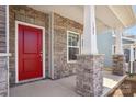 Inviting front porch featuring stone pillar bases, a bright red door, and house number at 109 Obadiah Ct, Troutman, NC 28115