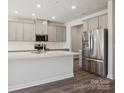Modern kitchen with a large island, stainless steel appliances, and sleek gray cabinets at 109 Obadiah Ct, Troutman, NC 28115