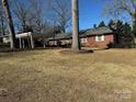 Brick ranch house with carport, large tree, and yard at 323 Breslin St, Wadesboro, NC 28170