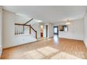 Bright living room featuring hardwood floors, staircase with wood banister, and ample natural light, ideal for entertaining at 8218 Legare Ct, Charlotte, NC 28210