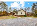 View of the house from the gravel driveway, showcasing the front porch and yard at 4450 Dobys Bridge Rd, Fort Mill, SC 29707