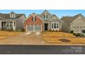 Two-story house with gray siding, brick accents, and a two-car garage at 7014 Jolly Brook Dr, Charlotte, NC 28215