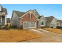 Two-story home with gray siding, brick accents, and a two-car garage at 7014 Jolly Brook Dr, Charlotte, NC 28215