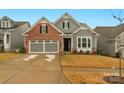 Gray and brick two-story house with a two-car garage and well-maintained lawn at 7014 Jolly Brook Dr, Charlotte, NC 28215