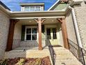 Inviting front porch with brick steps, decorative pillars, and a cheerful green door at 959 Tamary Way # 29/30, Landis, NC 28088