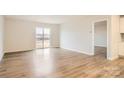 Bright Gathering room featuring light wood laminate flooring and sliding glass doors at 108 Mountain Bridge Way, Statesville, NC 28625