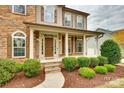 Inviting front porch with stone steps, columns, and lush landscaping offering curb appeal at 373 Fischer Rd, Fort Mill, SC 29715