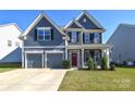 Charming two-story home with a well-manicured lawn, a two-car garage, and a welcoming red front door at 3877 Lake Breeze Dr, Sherrills Ford, NC 28673