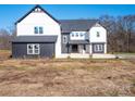 Two-story farmhouse with black and white exterior, attached garage, and landscaping at 3907 E Lawyers Rd, Monroe, NC 28110