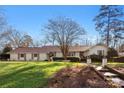 Charming single-story home boasts a well-manicured lawn and inviting walkway, blending classic architecture with serene landscaping at 946 Scotch Dr, Gastonia, NC 28054