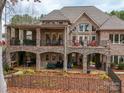 A two-story brick house featuring outdoor seating and entertaining space, stone patios, and a fenced backyard at 1140 Inlet Pointe Rd, Salisbury, NC 28146
