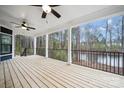 Spacious covered back porch offering serene views of a lush, wooded landscape and glistening pond at 357 Triple Ponds Ct, Clover, SC 29710