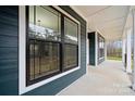 Charming covered front porch showcasing wood-look siding, black framed windows, and classic white trim at 357 Triple Ponds Ct, Clover, SC 29710
