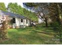 View of a spacious lawn with trees and shaded areas behind a single-story home at 155 6Th Sw St, Taylorsville, NC 28681