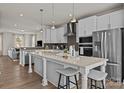 A modern kitchen featuring white cabinets, stainless steel appliances, and a large island with seating at 5019 Layman Dr # 26, Charlotte, NC 28226