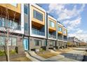 Modern townhomes feature brick facade, wood accents, balconies, and eye-catching blue doors at 819 E 36Th St, Charlotte, NC 28205