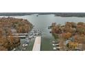 Aerial view of a lake community featuring boat docks, waterfront homes surrounded by colorful autumn trees at 26022 Misty Way Dr, Tega Cay, SC 29708