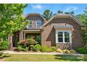 Charming brown brick home with stone accents, landscaped front yard, and inviting curb appeal at 16515 Governors Club Ct, Charlotte, NC 28278