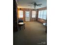 Cozy living room with classic wood paneling, natural light, and a ceiling fan; ideal for relaxation at 116 Lodge Hall Ct, Stony Point, NC 28678