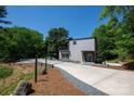 Modern home featuring a sleek exterior, spacious driveway, and lush greenery at 6534 Providence Rd, Charlotte, NC 28226
