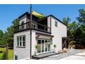 A contemporary two-story home featuring a balcony, modern siding and lush landscaping at 6534 Providence Rd, Charlotte, NC 28226