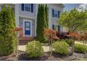 Close-up of the front entrance highlighting the blue door and meticulously maintained landscaping at 10029 Daufuskie Dr, Charlotte, NC 28278