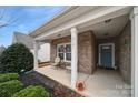 Inviting covered front porch with seating area, brick facade, and well-maintained landscaping at 2481 Bergamot St, Tega Cay, SC 29708
