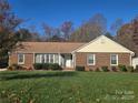 Charming single-story brick home with well-maintained front yard, blue skies and mature landscaping at 433 Pamela St, Gastonia, NC 28054