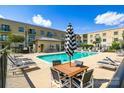 Exterior view of community pool and seating area featuring lounge chairs and shade umbrellas at 721 Governor Morrison St # 425, Charlotte, NC 28211