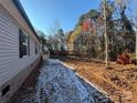 Side view of the home showing light gray siding, black shutters, and tree-lined surroundings at 3553 33Rd Street Ne Dr, Hickory, NC 28601