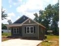 Stylish one-story home with green siding, black shutters, and a concrete driveway and sidewalk at 1589 Maysville Rd, Shelby, NC 28150
