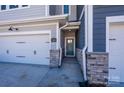 Close-up of a townhome entrance with a stylish front door, stone accents, and a well-lit walkway at 161 Halite Ln, Waxhaw, NC 28173