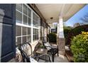 Inviting front porch with two black wicker chairs and a small table at 7534 April Mist Trl, Huntersville, NC 28078