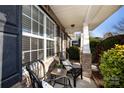 Inviting front porch with brick columns, two wicker chairs, and small table at 7534 April Mist Trl, Huntersville, NC 28078