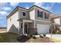 Two-story home featuring neutral siding, black shutters, a covered entryway, and manicured landscaping at 3033 Eastcott Ave, Monroe, NC 28110