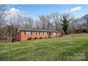 Inviting red brick home set on a spacious lawn with mature trees adding to the property's charm at 216 Delview Dr, Cherryville, NC 28021