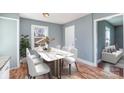 Modern dining room with a stylish table, chairs, wood floors and lots of natural light from the window at 2630 Druid Hills Way, Charlotte, NC 28206