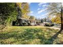 Wide angle of a cozy home with spacious front yard, lush green grass and mature trees at 2630 Druid Hills Way, Charlotte, NC 28206