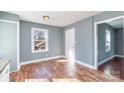 Empty room features blue walls, wood floors, a single window, and view into an adjacent room at 2630 Druid Hills Way, Charlotte, NC 28206