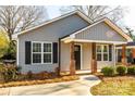 Gray house with a covered porch, brick columns, and black shutters at 267 Elm Nw Ave, Concord, NC 28025