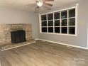 Bright living room featuring a stone fireplace, ceiling fan, and new flooring at 2040 Ne 25Th Street Dr, Hickory, NC 28601