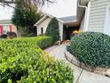Inviting front entrance with lush greenery, a paved walkway, and neutral-colored siding at 8430 Stoneman Pl, Charlotte, NC 28217