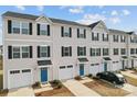 A row of townhomes featuring blue doors, white garages and siding, and neatly trimmed landscaping at 2409 Fathom Way, Charlotte, NC 28269