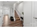 A bright hallway featuring hardwood floors, a staircase, and a door to the exterior at 2409 Fathom Way, Charlotte, NC 28269
