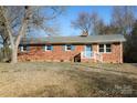 Brick ranch house with blue shutters, white steps, and landscaping at 31655 Pinewood Dr, New London, NC 28127