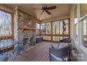 Relaxing screened porch with stone fireplace, wicker furniture, and wood floors at 404 Yorkfield Dr, Shelby, NC 28150