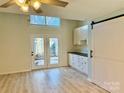 Living room features wood-look floors, high ceilings and a sliding barn door at 6130 Heathstone Ln, Charlotte, NC 28210