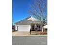 Yellow ranch home with a gray roof, attached garage, and well-maintained lawn at 1001 Jessica Ln, Matthews, NC 28104